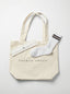 Beige tote bag with white socks and a small white box 