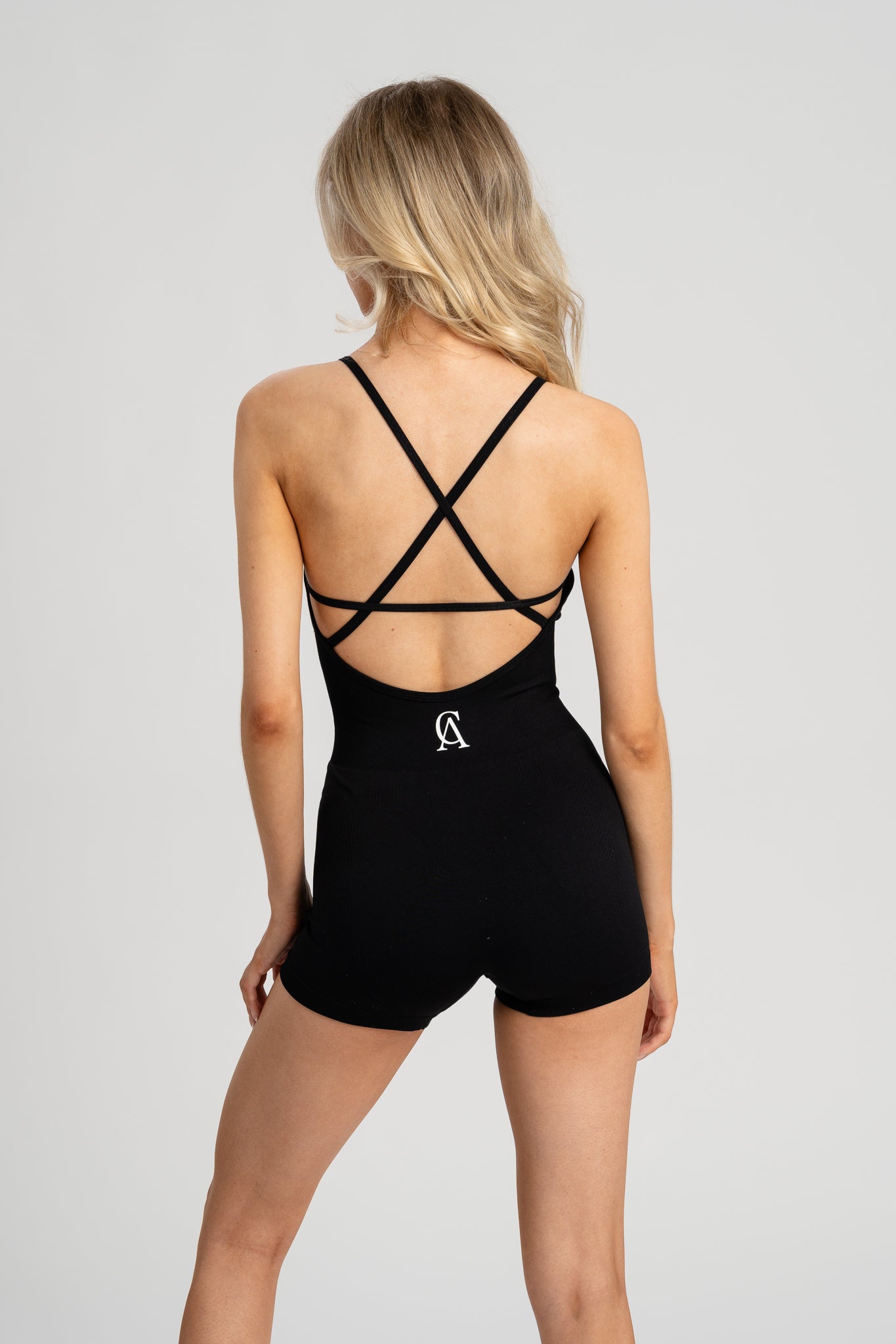 Breathable women’s romper with crisscross back and flattering fit.